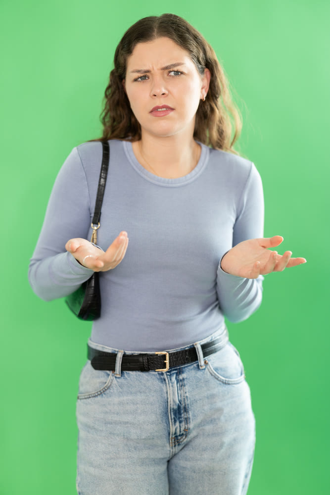 Young woman confused and forgetful in front of green screen