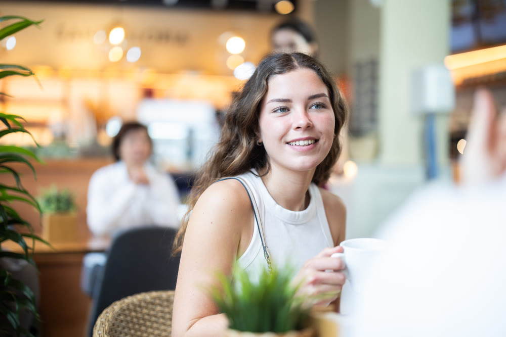 Young woman talking to guy in coffee shop