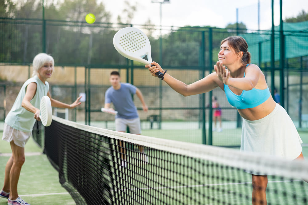 Women playing padel tennis match during training on court
