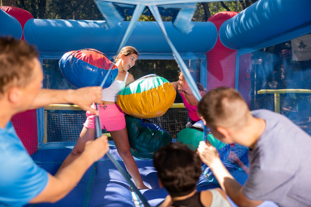 Women having pillow fight between each other in outdoor amusement park