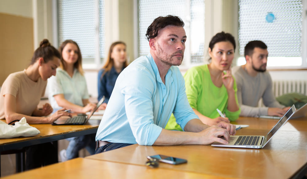 Man using laptop during lesson in university