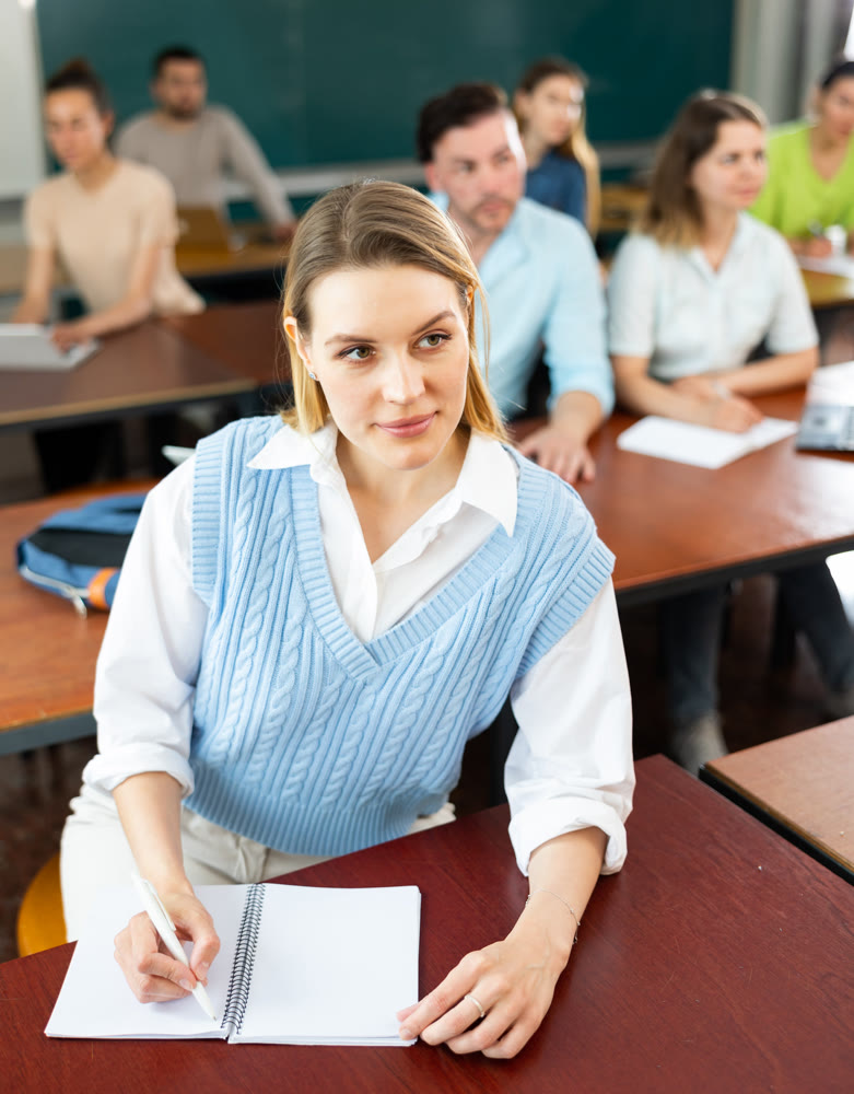 Portrait of an adult positive female student during class in university auditorium
