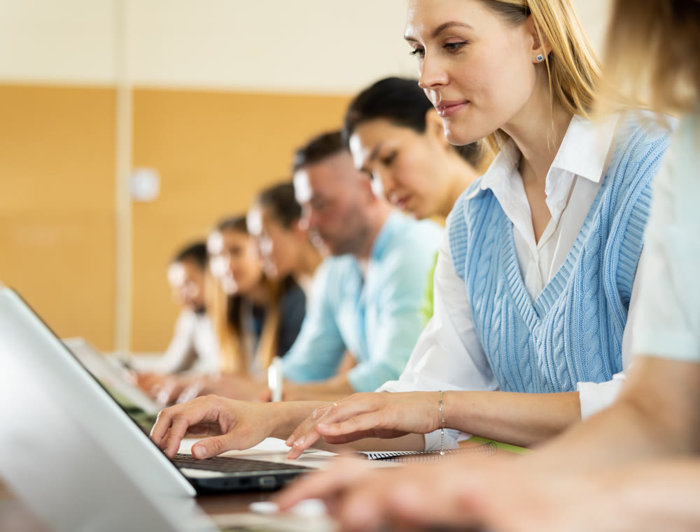 Group of students attentively listening to lecture in university classroom