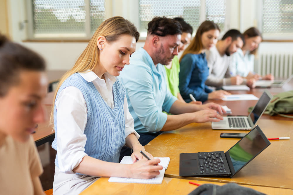 Woman university student sitting at table and handwriting