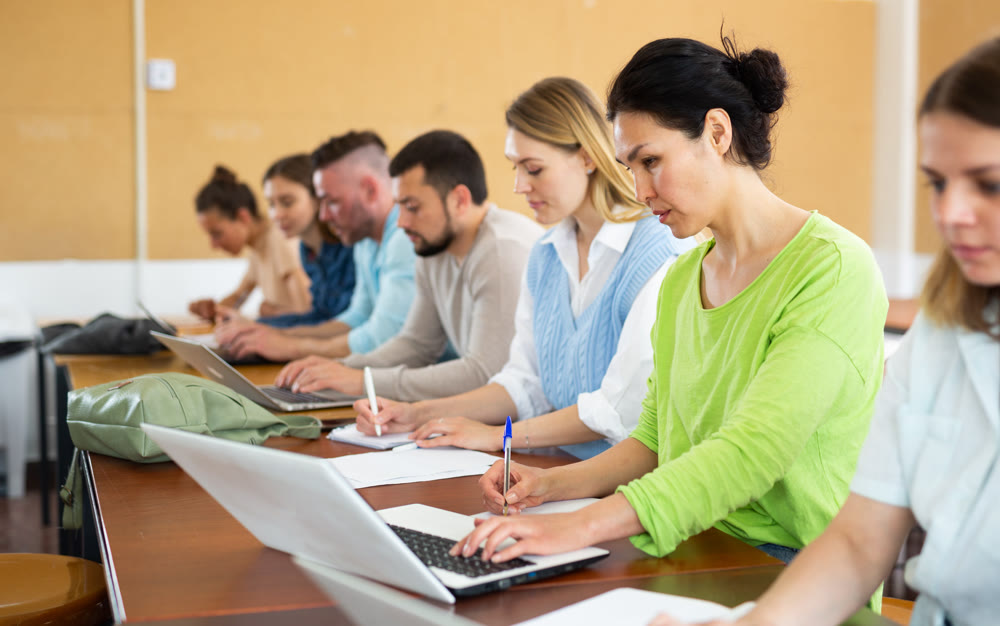 Group students listening and writing during business course