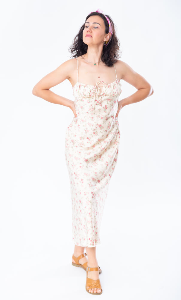 Portrait of an attractive slim woman in long summer dress on white background
