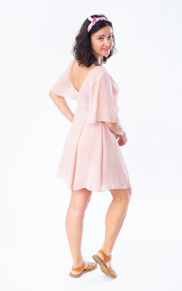 Portrait of an attractive adult woman in a pink dress on white background
