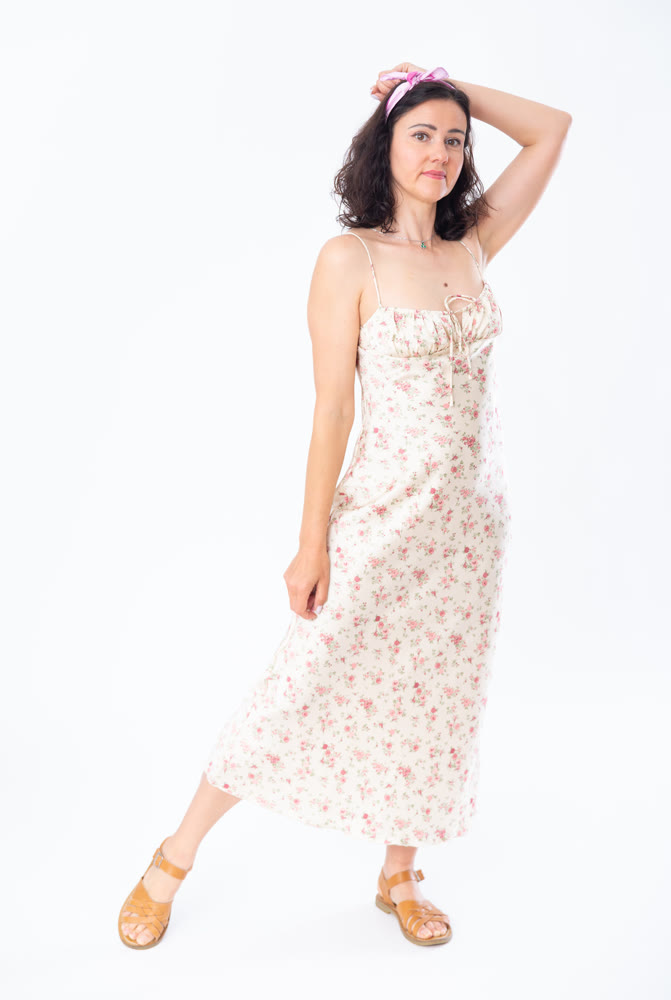 Portrait of an attractive slim woman in long summer dress on white background