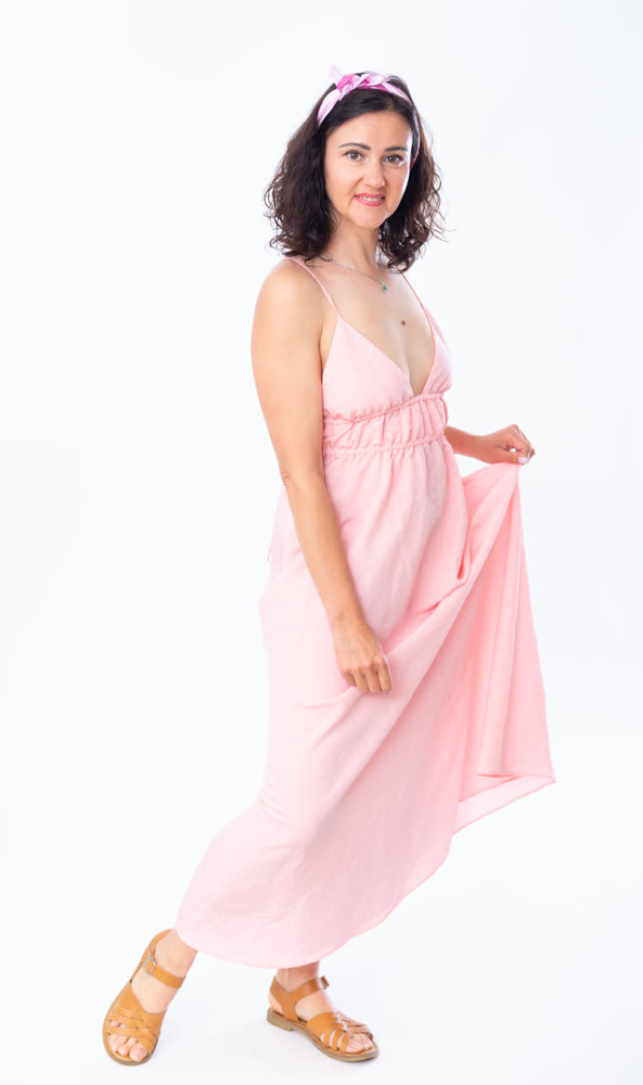 Portrait of an attractive adult woman in a pink dress on white background