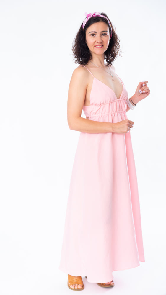 Portrait of an attractive adult woman in a pink dress on white background