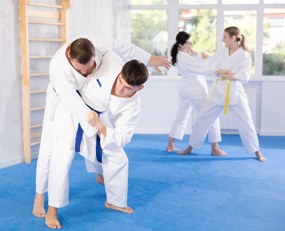 Adult man and young guy training judo techniques