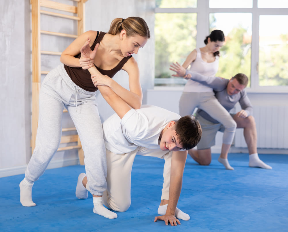 Young woman and guy training self-defense techniques