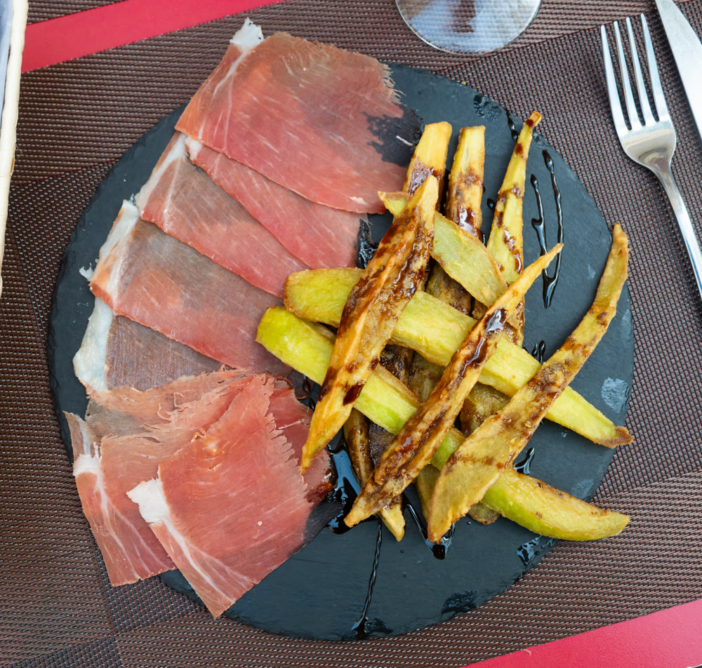 Warm baked appetizer made of slices of pork bacon and pieces of eggplant