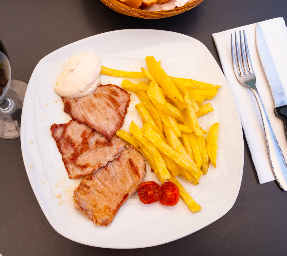 Fried pork with potatoes, fresh tomatoes and sauce