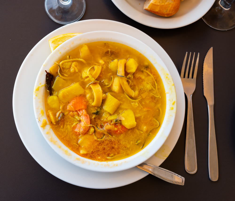 Traditional Spanish soup with seafood in a bowl view from above