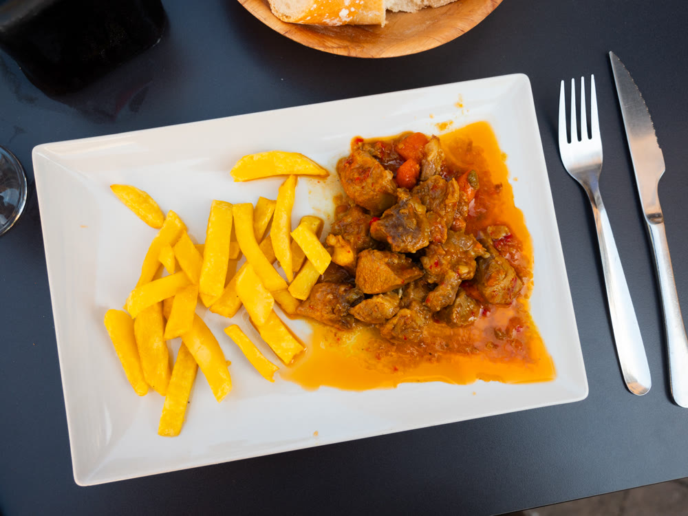 Stewed veal in sauce on a plate with vegetables