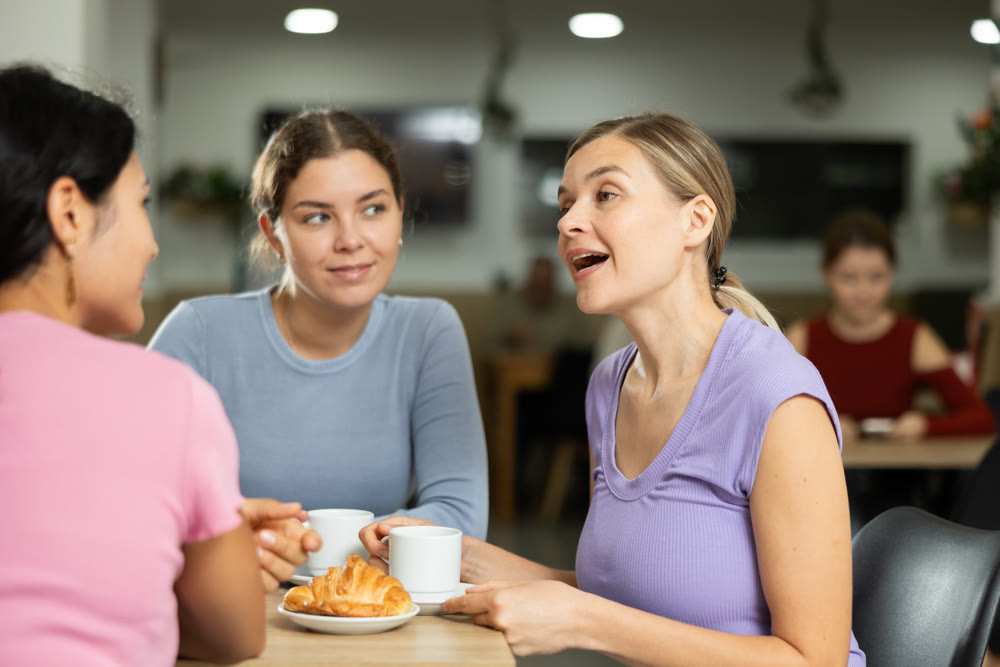 Three girls are chatting sweetly during tea party