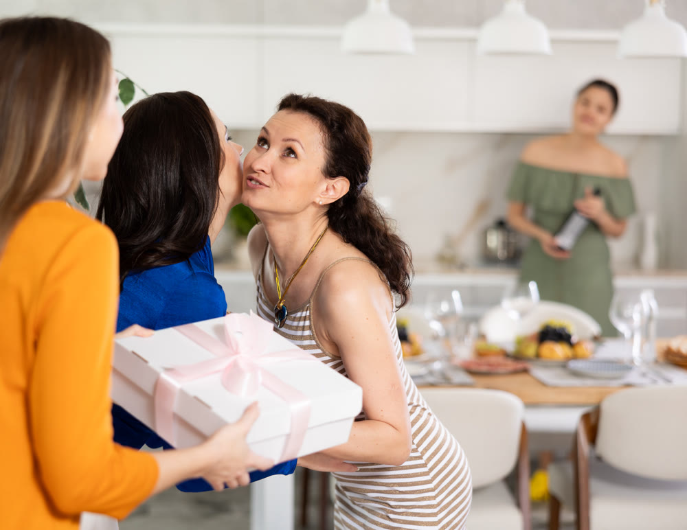 Group of women greeting each other and giving gift