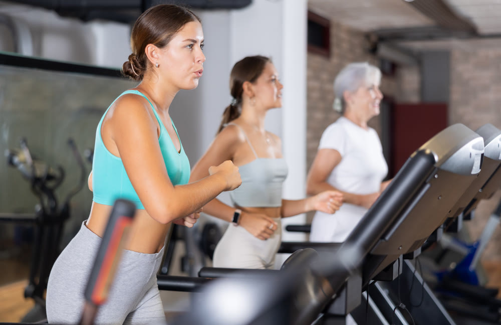 Woman doing cardio workout running on treadmill at fitness center