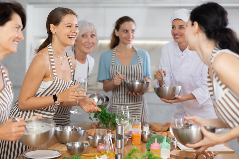 Young woman talks and drinks with group during master class