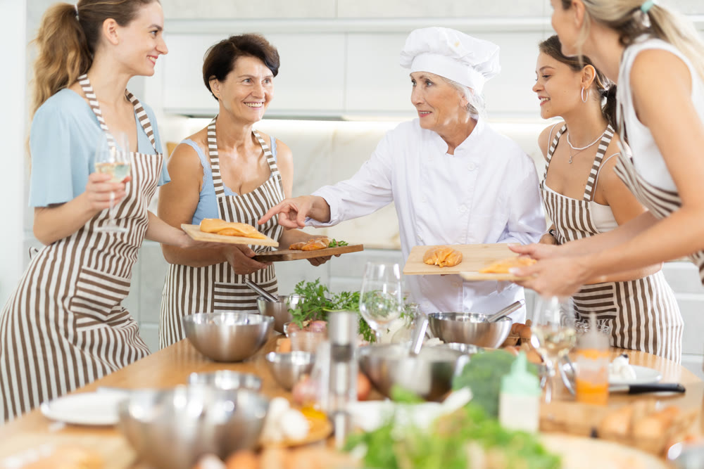 Mature female cook holding cutting board with raw chicken