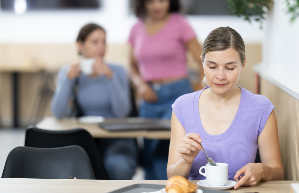 Adult woman drinks coffee with croissant