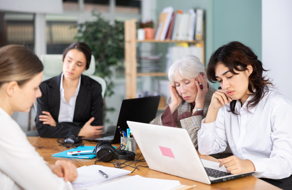 Young woman sitting tired and sad at office desk