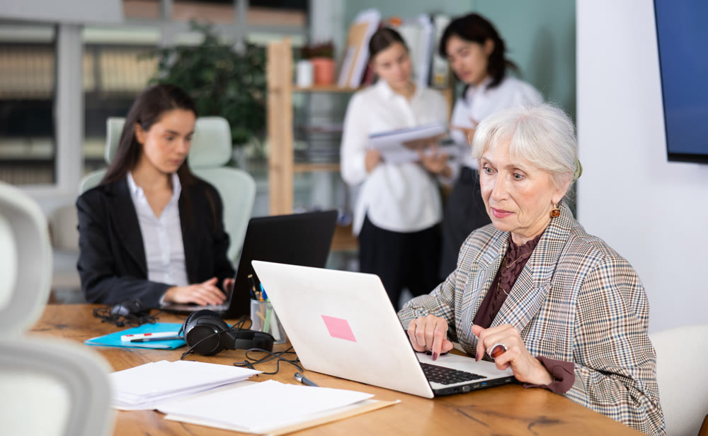 Office staff perform tasks and corporate deadlines during working day.
