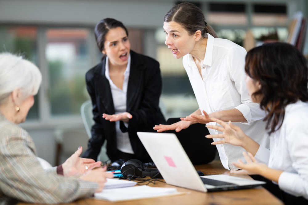 Angry group of female colleagues arguing during office meeting