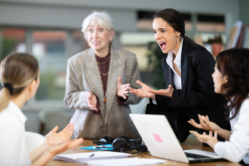 Angry group of female colleagues arguing during office meeting