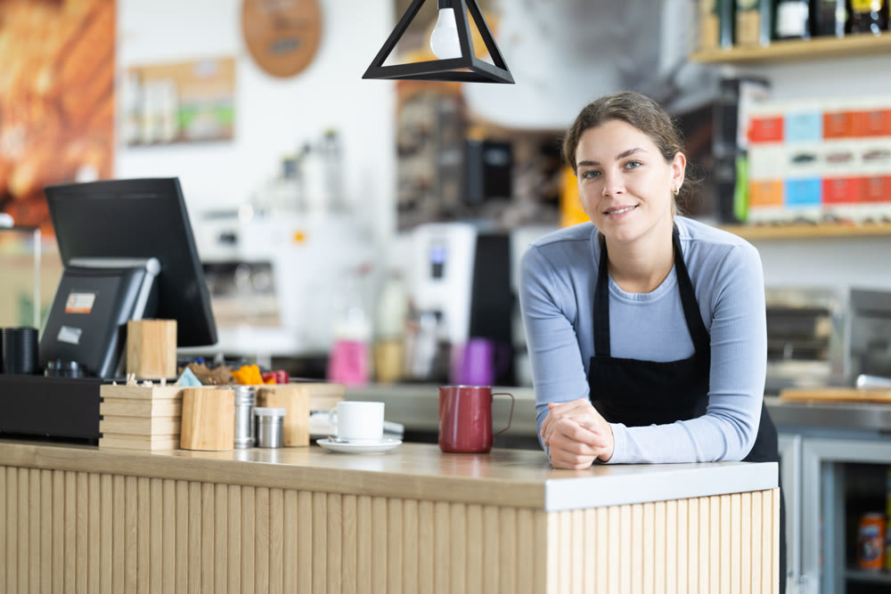 Polite waitress welcomes clients in cafeteria