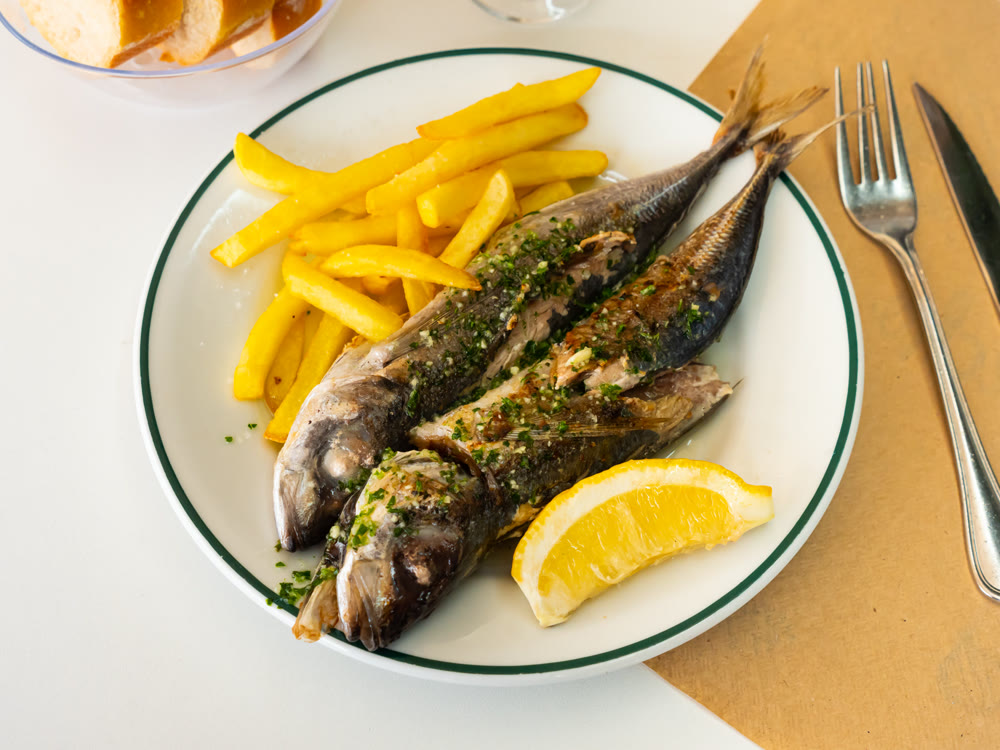 Grilled mackerel fish with french fries and lemon