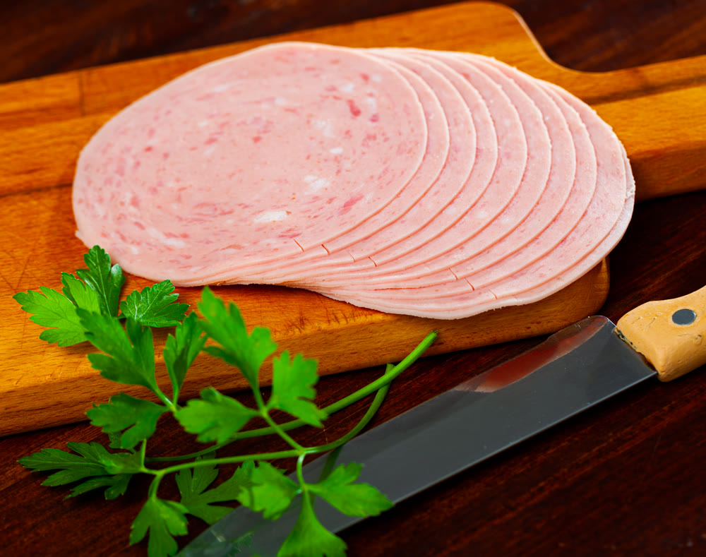 Sliced ham on wooden background