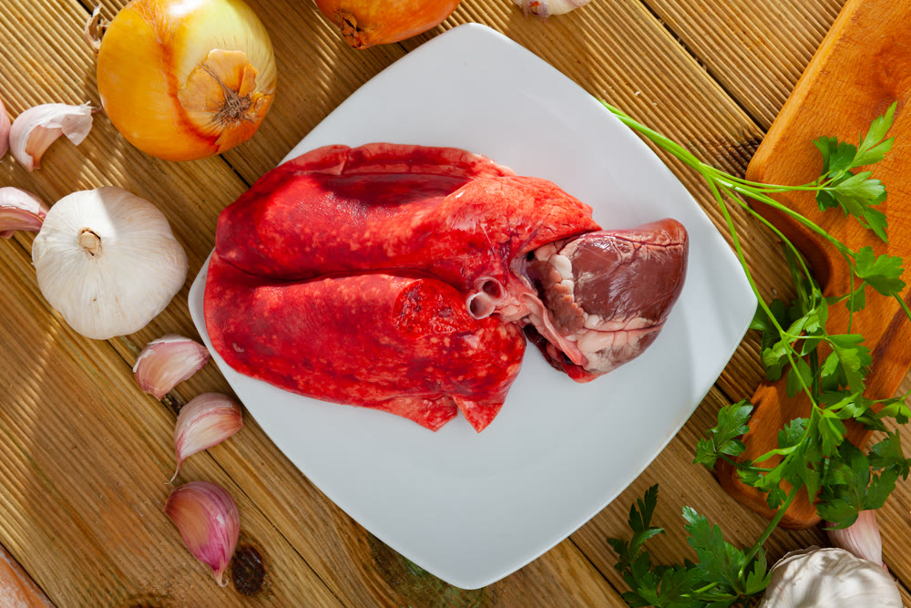 Raw lamb lungs and heart served with greens, nobody