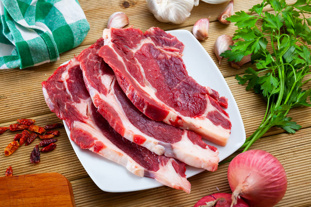Image of raw veal with greens and spice before cooking