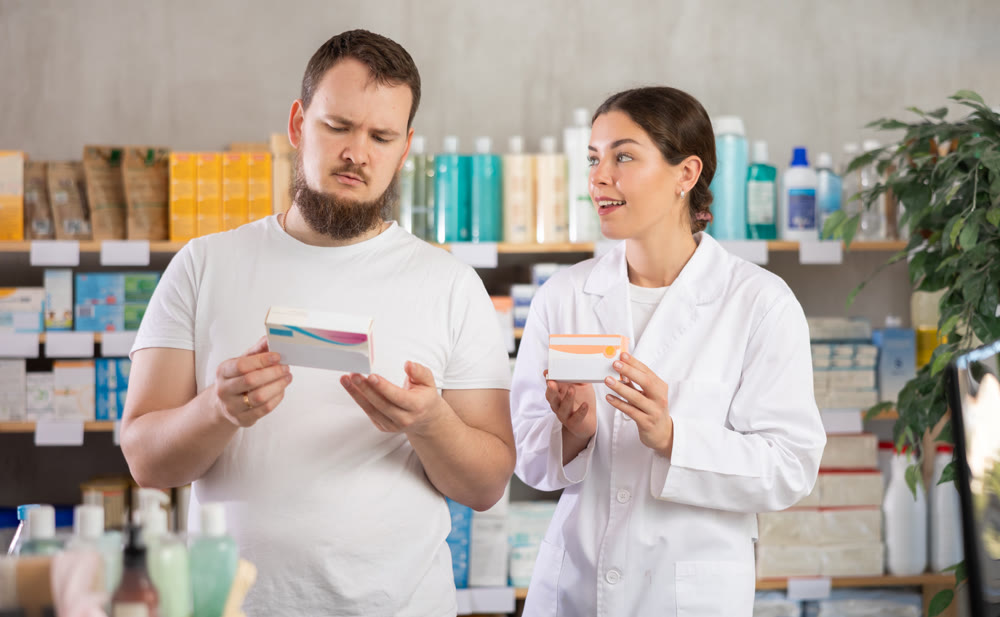 Man choosing pills with help from pharmacist
