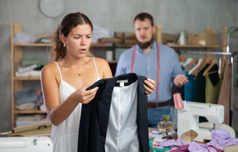 Disappointed customer reacting to defect in custom-made jacket