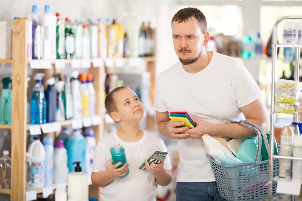 Man and boy choosing household chemicals in store