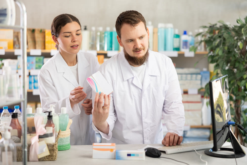 Two pharmacists working at a computer