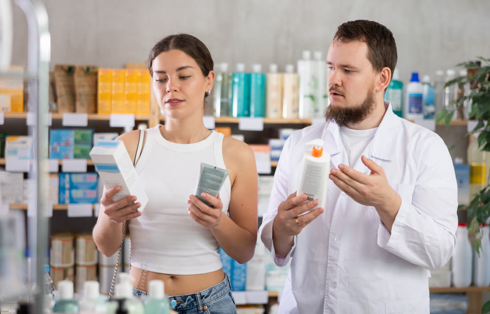 Woman choosing cream with help from pharmacist