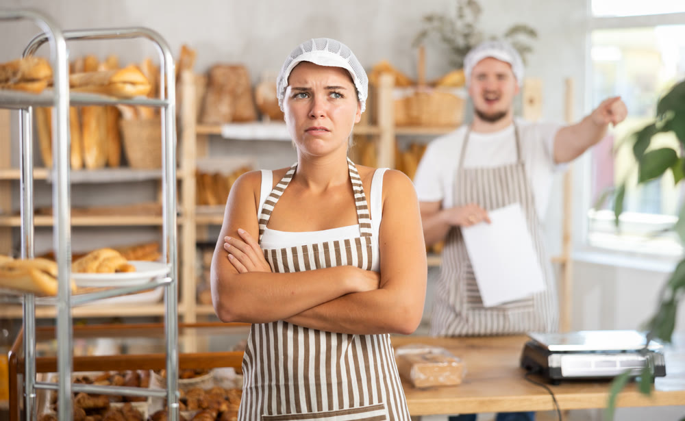 Young girl stands with her back to angry man pointing at the door
