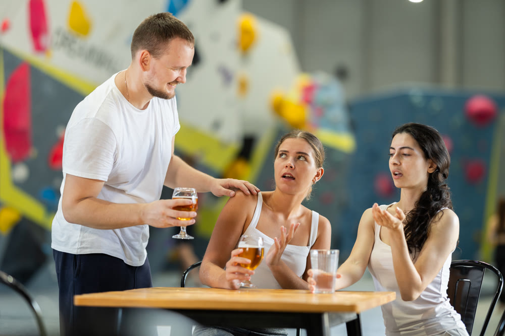 Man tries to pick up young girls after rock climbing training. Girls refuse to talk to him. Man flirting with disappointed girls