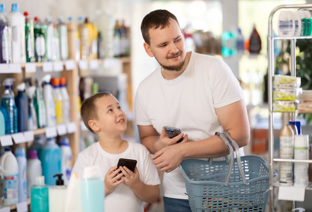Man and boy choosing household chemicals in store