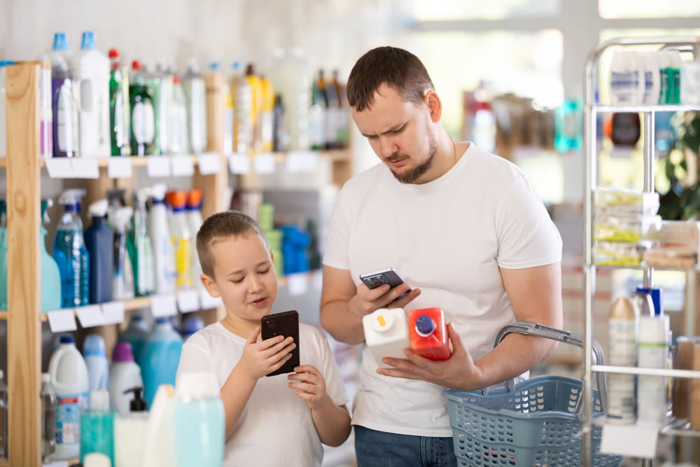 Dad and son scan barcode on packaging of sewer cleaner liquid