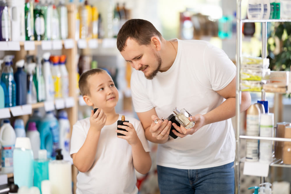 Dad and son client sniffs fragrance of perfume, chooses scent spray with pleasant smell