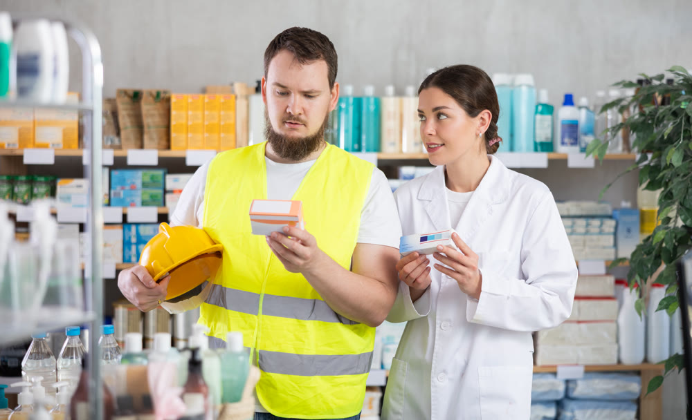 Laboring man builder buys pills at pharmacy, consulting with girl pharmacist