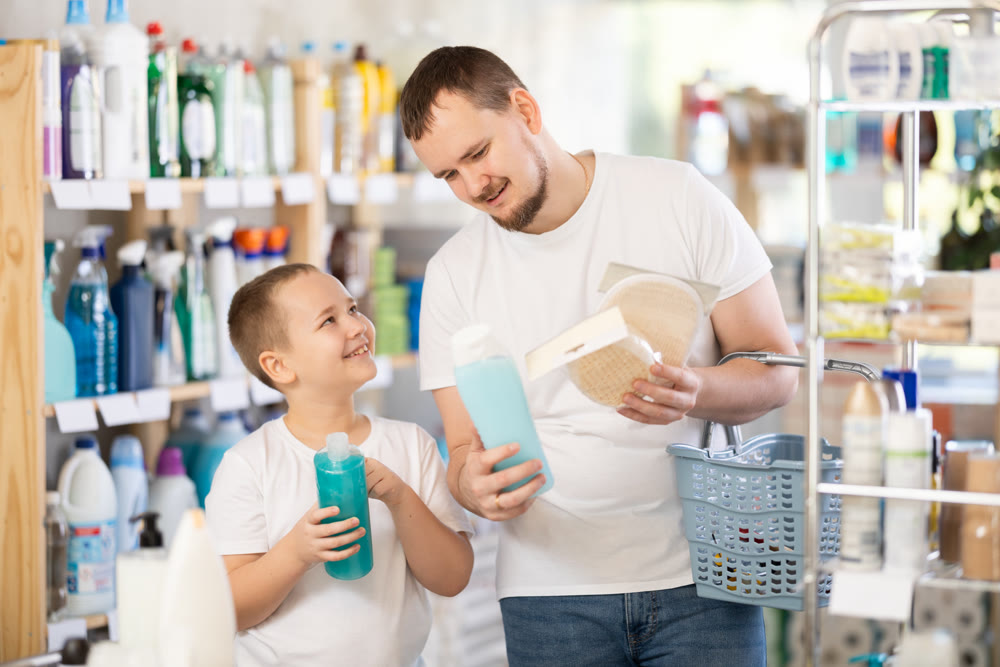 Schoolboy son and dad are choosing bast wisp and shower gel in store