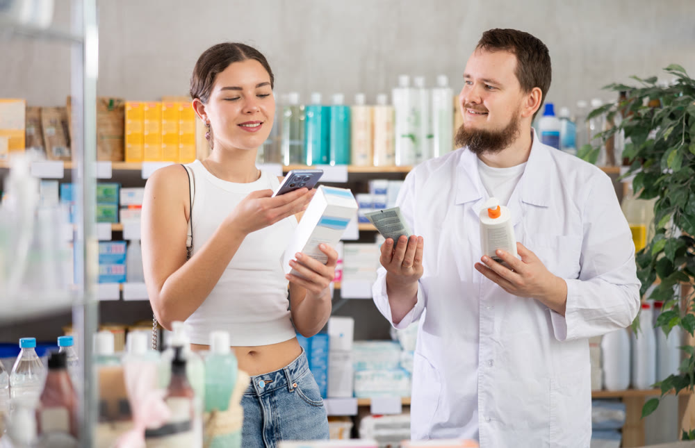 Woman scans QR code on skin creamp label. Male pharmacist offers to choose skin creamp
