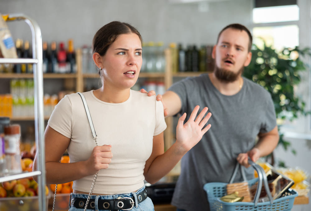 Angry girl turned away from husband during quarrel, he want to make peace after quarrel, calm wife