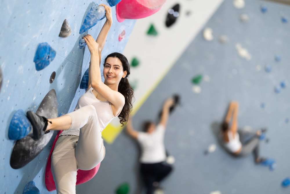 Young woman doing rock climbing on climbing wall